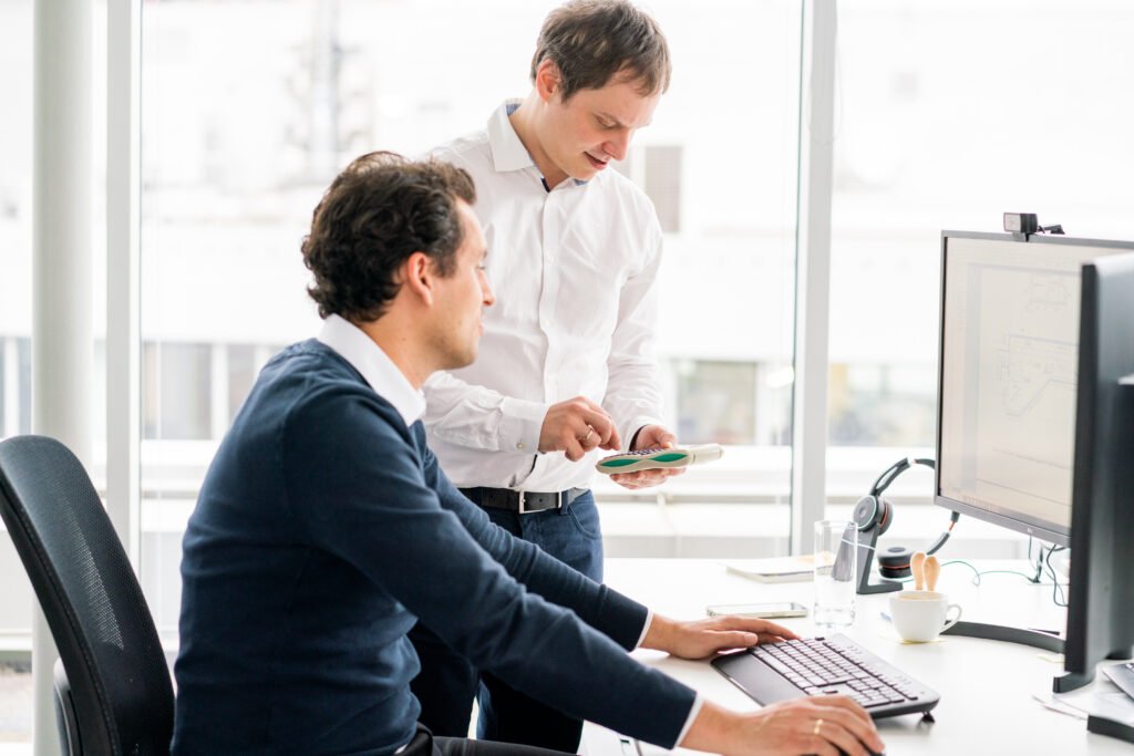 Bild zeigt zwei Mitarbeiter von KV Ingenieuren vor Ihren Computern bei der Arbeit.