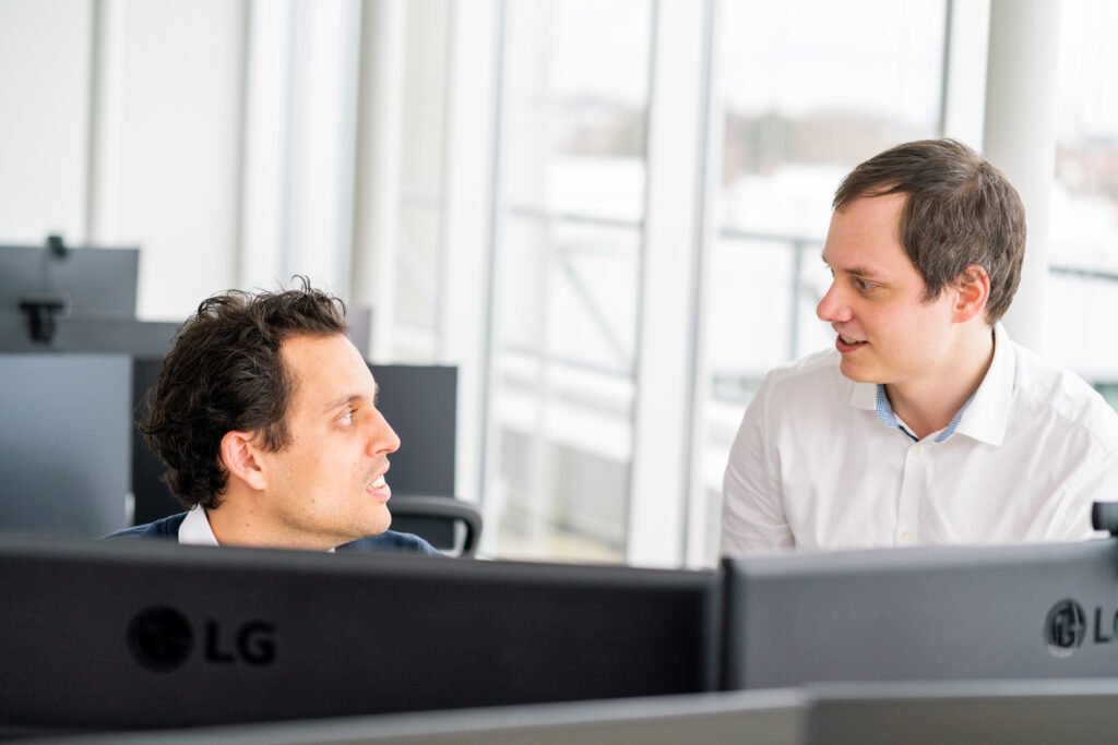 Bild zeigt zwei Mitarbeiter von KV Ingenieuren vor Ihren Computern bei der Arbeit.